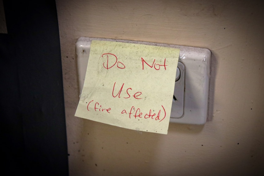 A sticky note on a power outlet reads "do not use, fire affected".