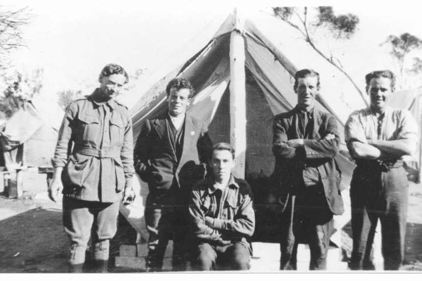 Returned WWI soldiers standing in front of a tent home.