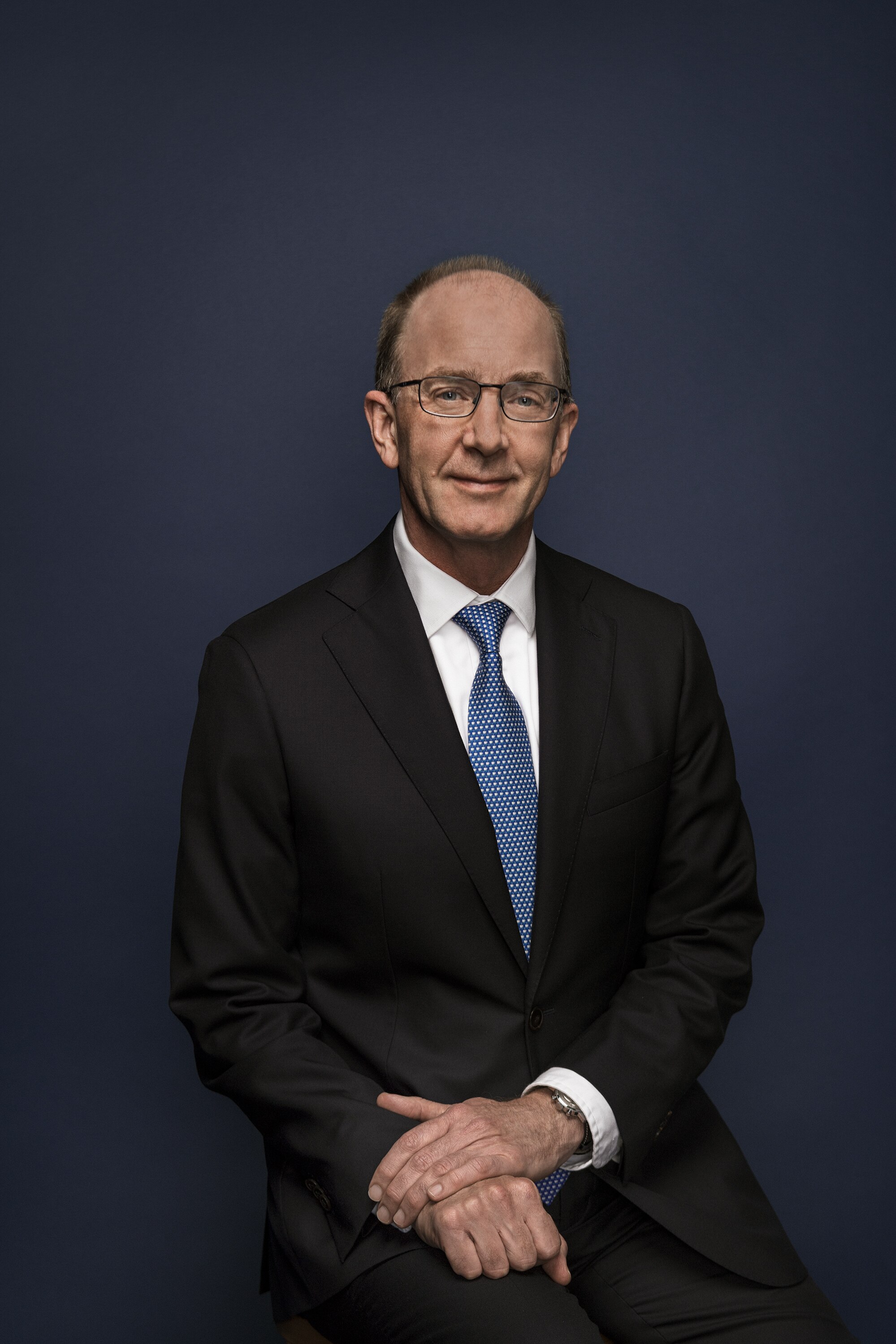 Angus Armour sits against a dark blue backdrop