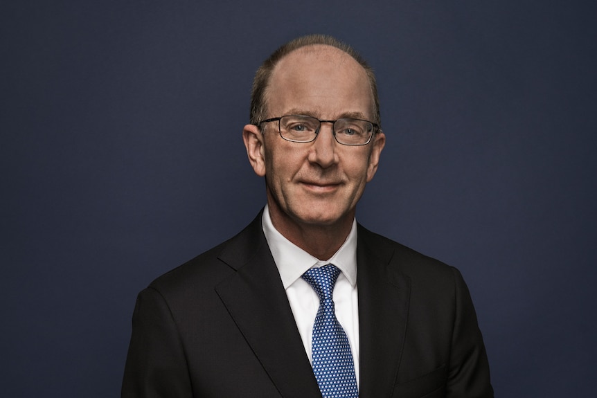 Angus Armour sits against a dark blue backdrop