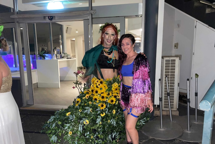 Drag queen in a skirt with vines and flowers entwined in it