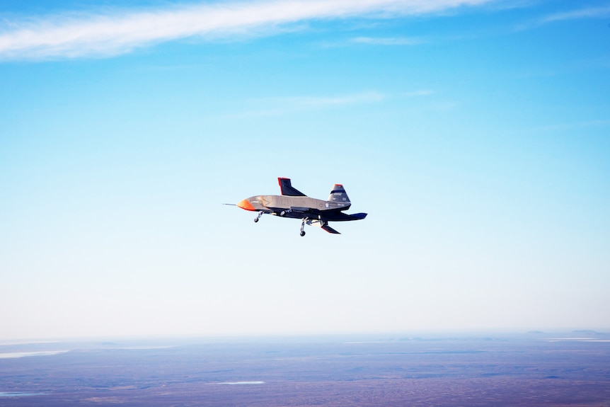 Loyal Wingman plane in flight in blue sky.