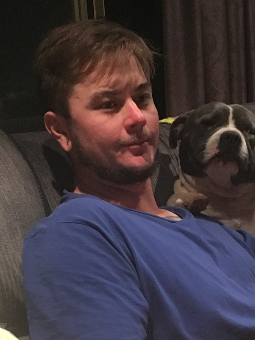 Jayden Usher sits next to a dog