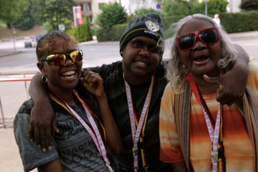 Three women stand arm in arm in Germany