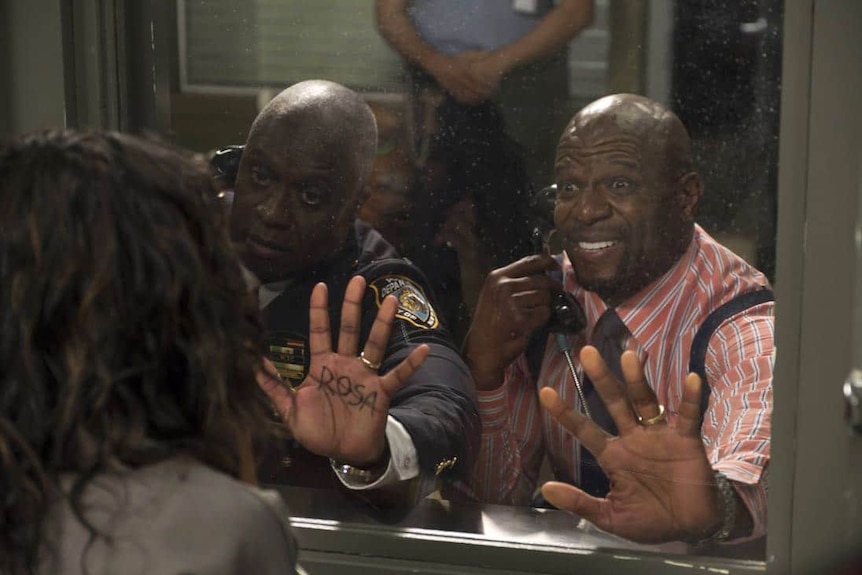 Terry Crews and his partner put their hands on the glass at a prison