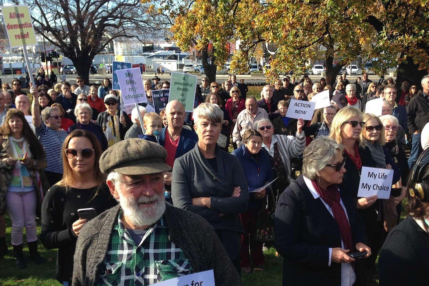 People hold placards in support of euthanasia outside Parliament in Hobart.