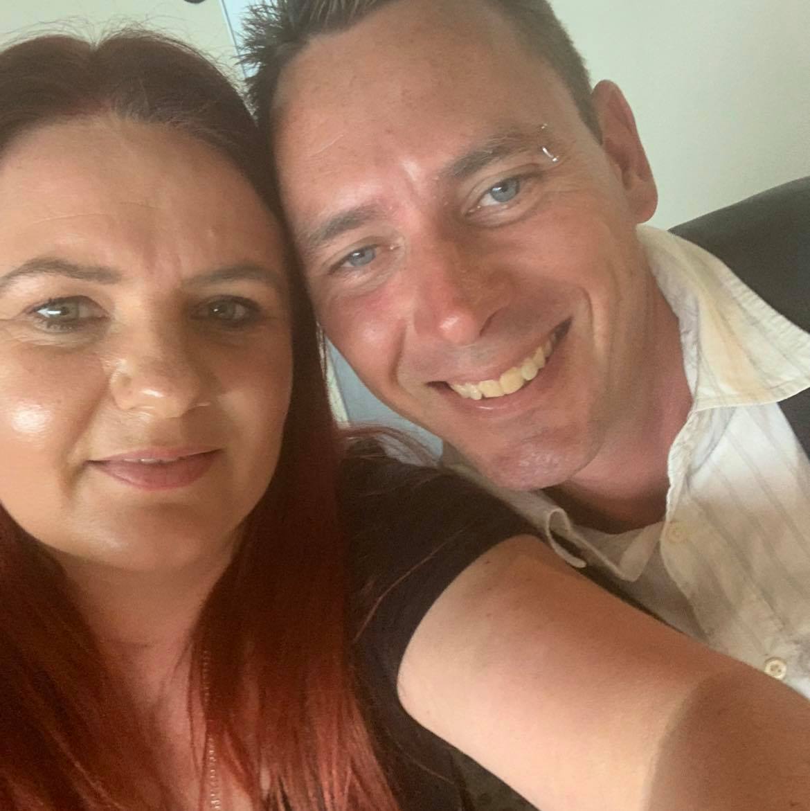 A woman and a man smile at the camera.