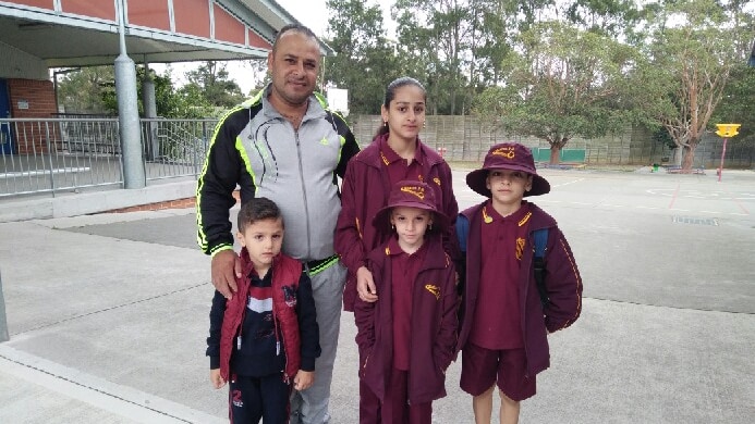 The Akhal family stand in the school classroom.