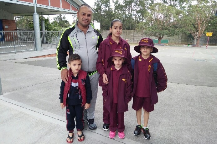 The Akhal family stand in the school classroom.