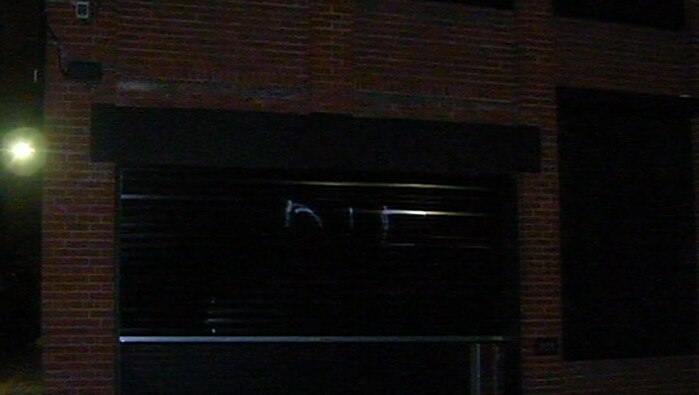 The word DIE is spray painted on a black roller door at a Fitzroy home.