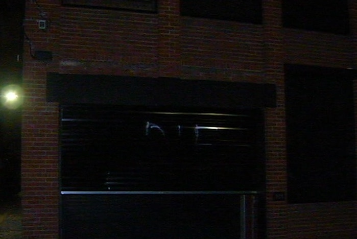 The word DIE is spray painted on a black roller door at a Fitzroy home.