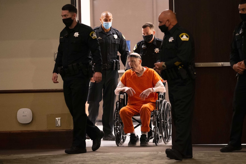 Police use a wheelchair to bring Joseph James DeAngelo into the courtroom.
