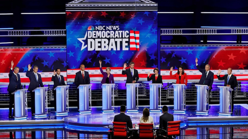 Ten Democrat politicians standing behind podiums on a stage.