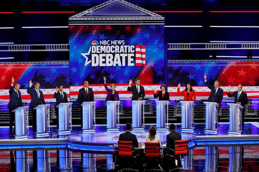 Ten Democrat politicians standing behind podiums on a stage.