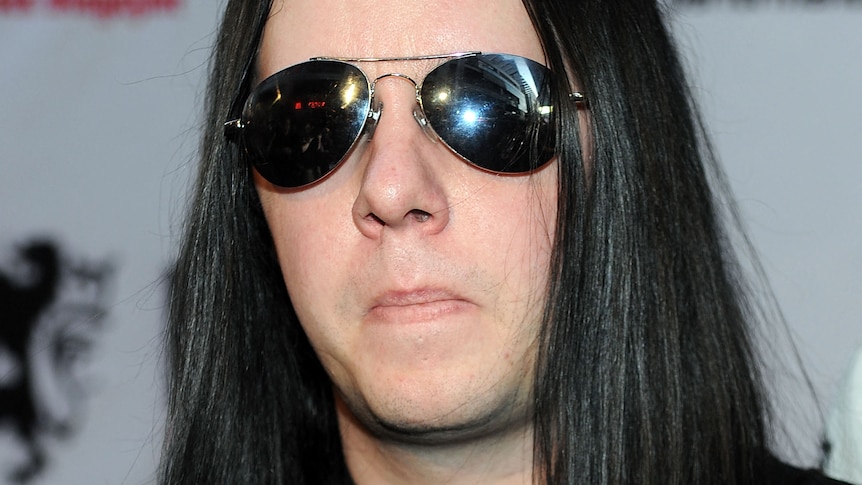 Joey Jordison with long black hair and waring dark sunglasses.