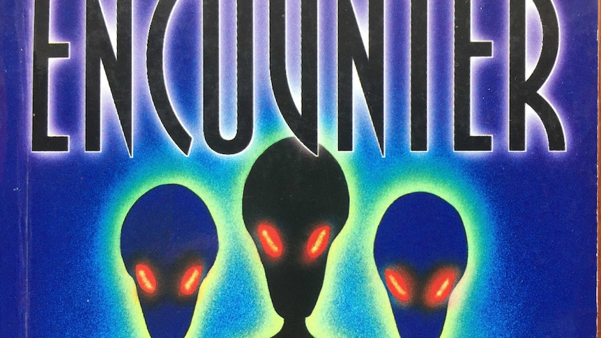 Part of the front cover of a book, featuring aliens with glowing red eyes and the word "Encounter".