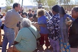 Mal Brough shakes hands with a person as he visits the Santa Teresa community in the NT