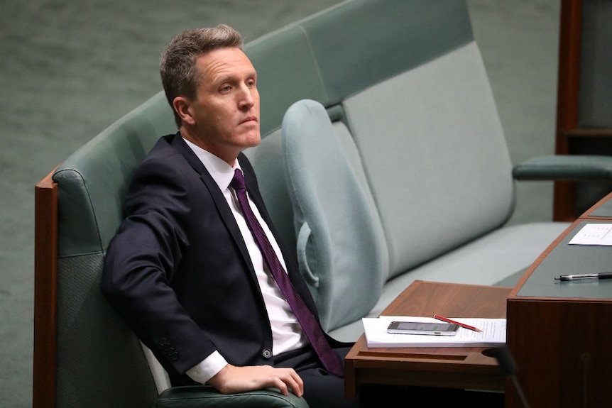 Josh Wilson looks serious while sitting in Parliament.