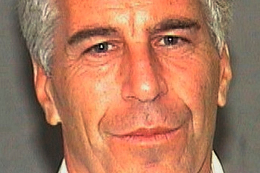 A photo of Jeffrey Epstein smiling at the camera against a blank background.
