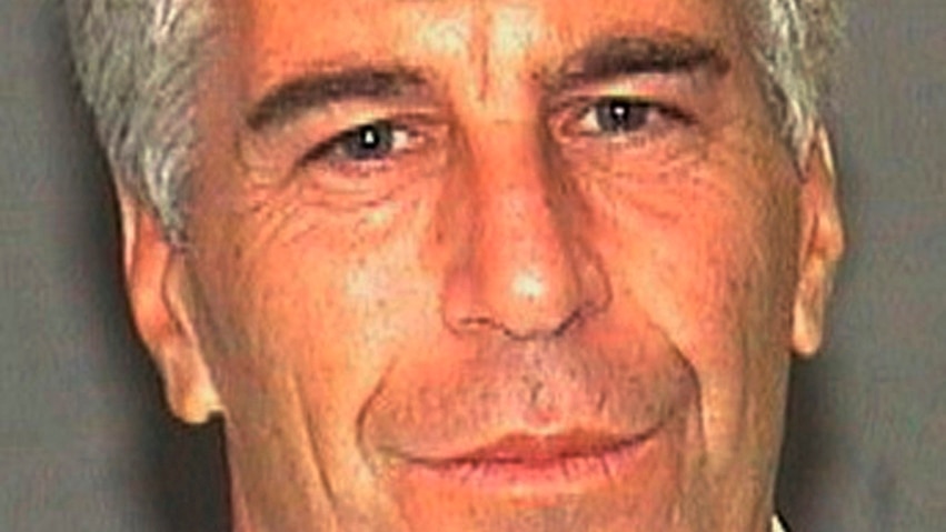 A photo of Jeffrey Epstein smiling at the camera against a blank background.