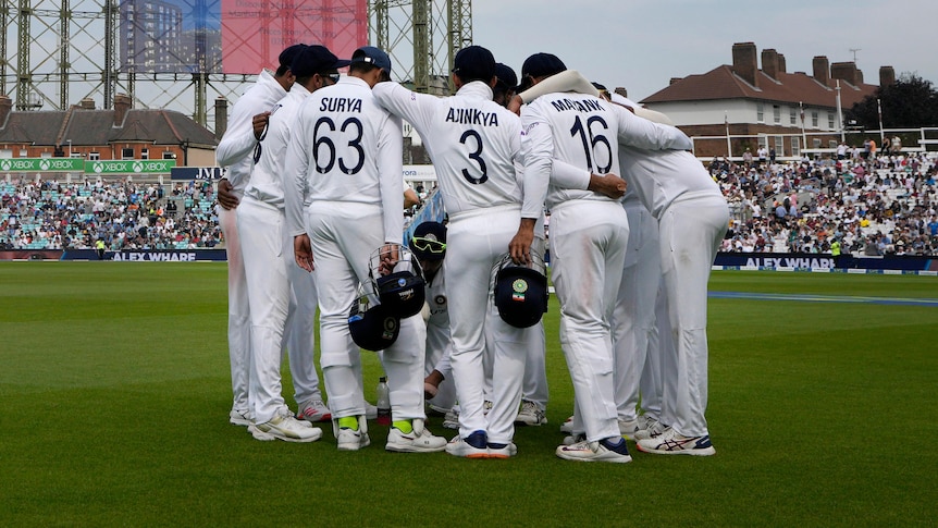 A group of Indian cricket players in a huddle during a Test against England.