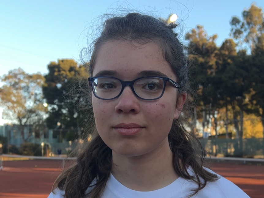 A young girl on a tennis court