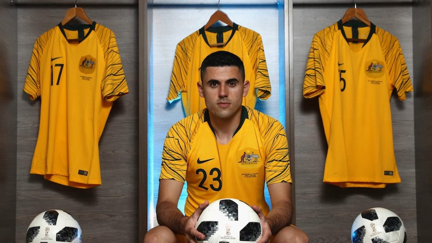 Tom Rogic poses for a formal portrait while wearing his Socceroos kit.