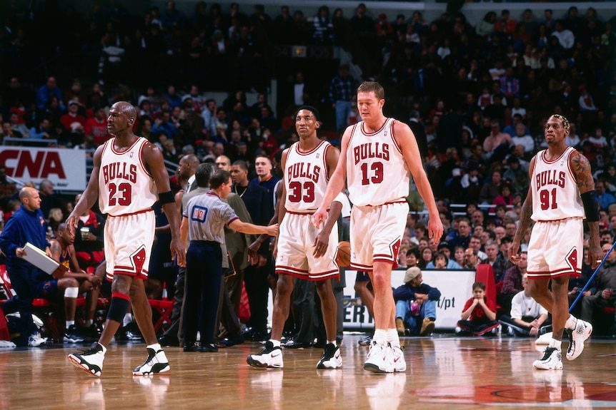 Chicago Bulls plays walk on the court in front of a large crowd- Jordan, Pippen, Longley and Rodman