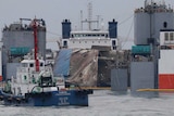 The sunken ferry Sewol is loaded onto a semi-submersible transport vessel.