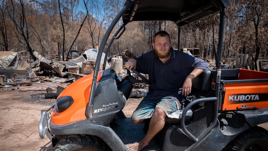 23-year-old man sitting on the seat in a quad bike parked in front of a house burnt to the ground.