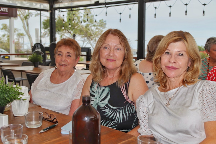 Three women sitting at a club. 