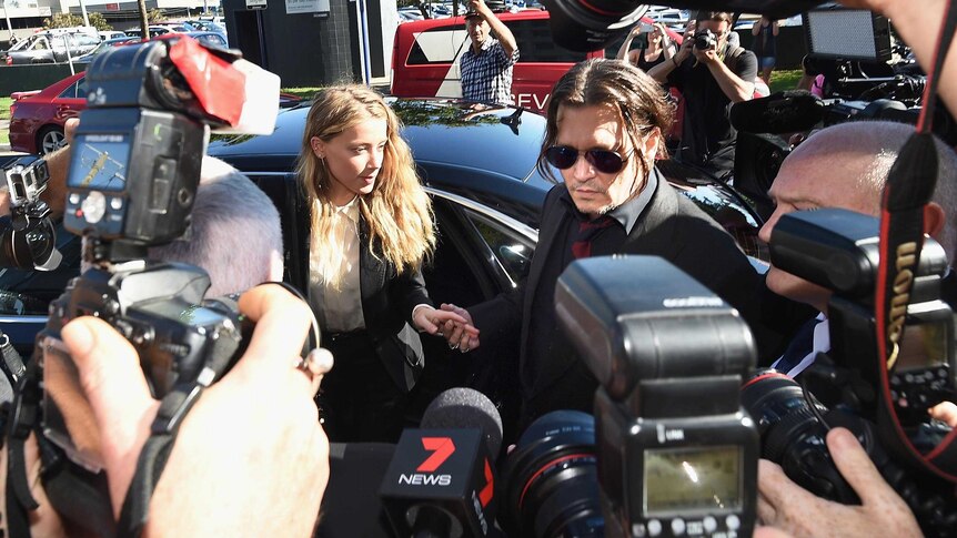 Johnny Depp and Amber Heard arrive at Southport Magistrates Court surrounded by cameras and microphones.