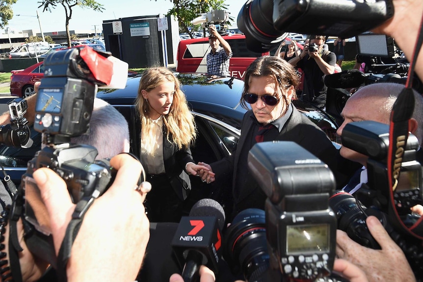 Johnny Depp and Amber Heard arrive at Southport Magistrates Court surrounded by cameras and microphones.