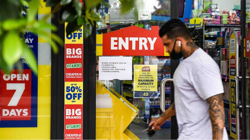 A man with a mask walks past a chemist