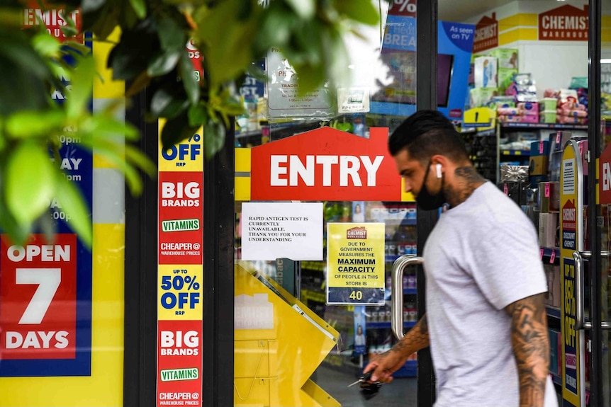 A man with a mask walks past a chemist