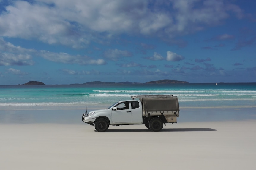 His ute drives along the beach