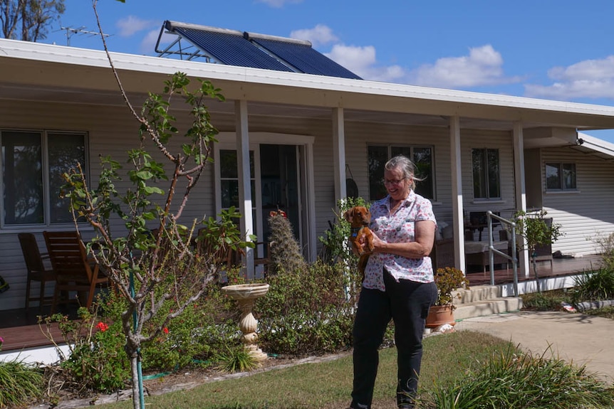 Sylvia Wilson and her dog Diggy in front of their home