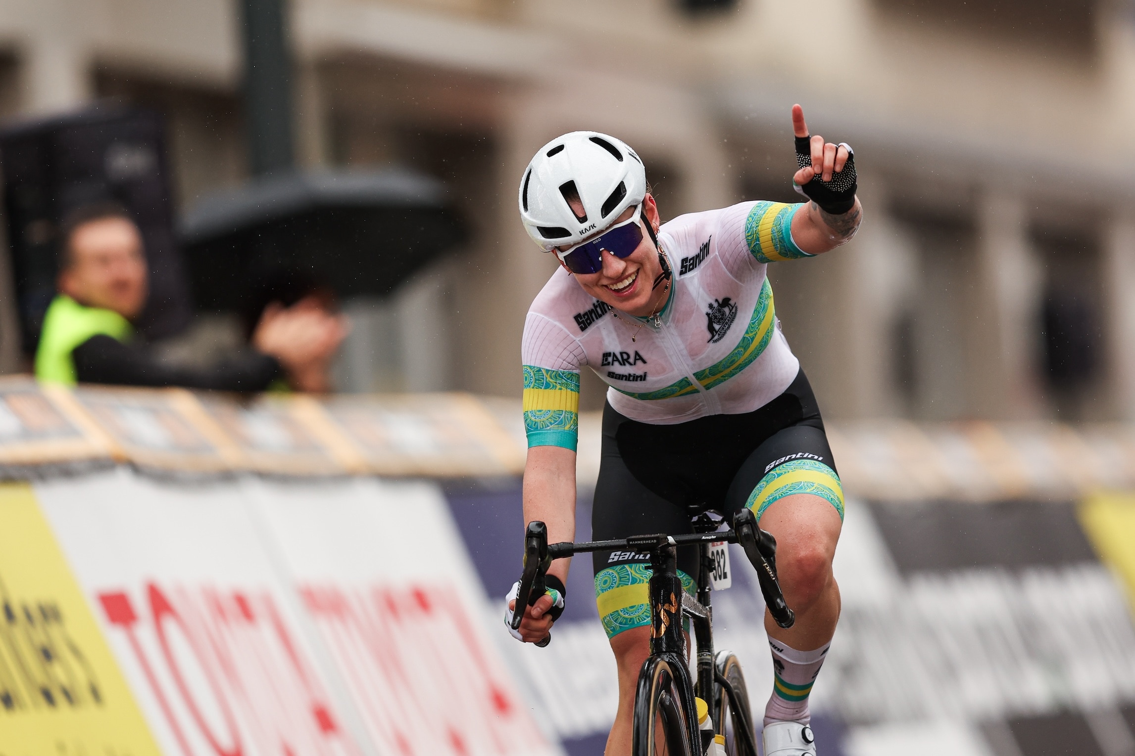 Tara Neyland holds up her hand on her bike