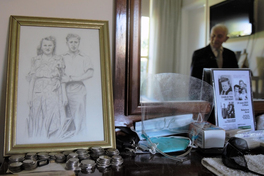 A framed sketch of a young Abram Goldberg and wife Cesia, beside a mirror in which can be seen Abram's blurred reflection.