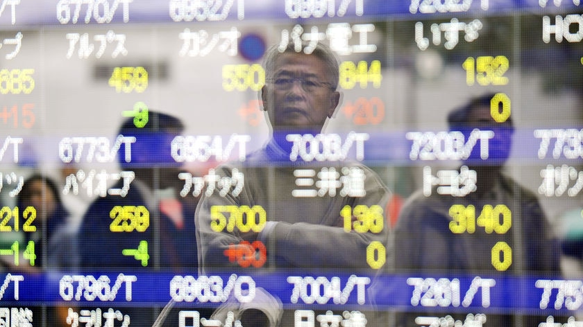 A man looks at quotation board flashing share princes of the Tokyo Stock Exchange (TSE)