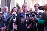 Colin Barnett, surrounded by colleagues, speaking to the media outside State Parliament.