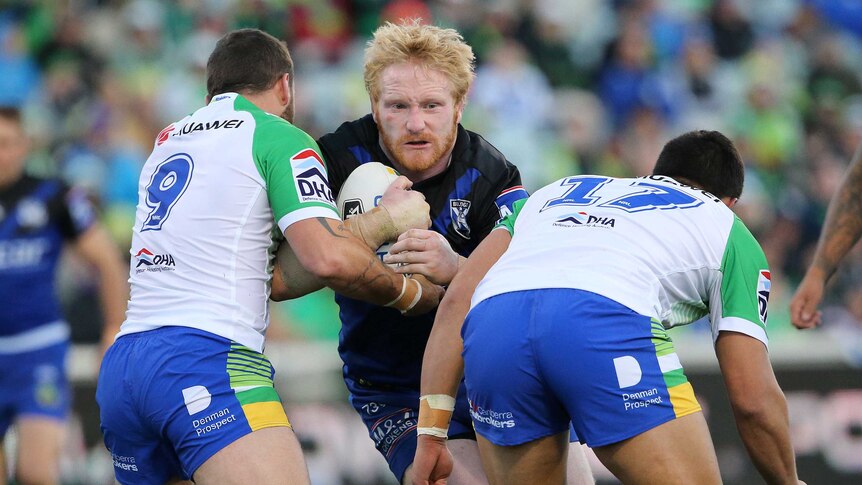 Gritty affair ... Bulldogs enforcer James Graham takes on the Raiders defence