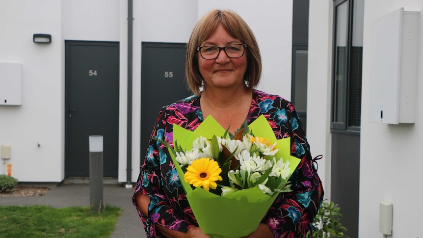 A woman holds a big bunch of flowers.