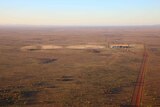 an aerial view of two centre pivots in the red Central Australian landscape.