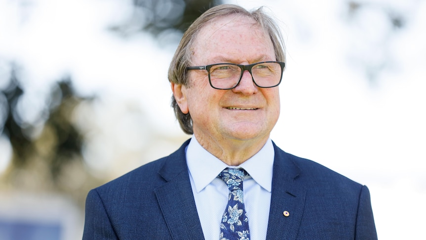 A photo of Kevin Sheedy standing at Royal Randwick Racecourse in 2019.