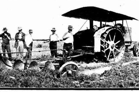 Men working with vintage tractor