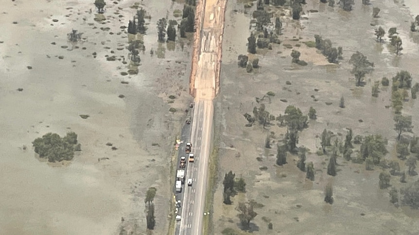 An aerial shot of a flooded and damaged road.