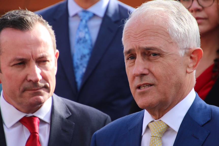 A close up shot of Mark McGowan in a suit and red tie and Malcolm Turnbull in a suit and yellow tie.