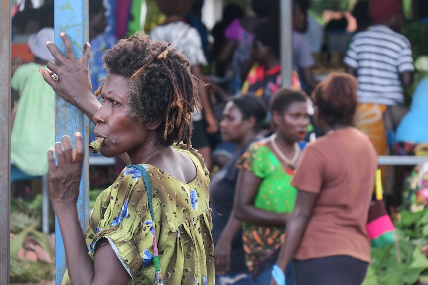 A woman chews betal nut at a market in Arawa, Bougainville.