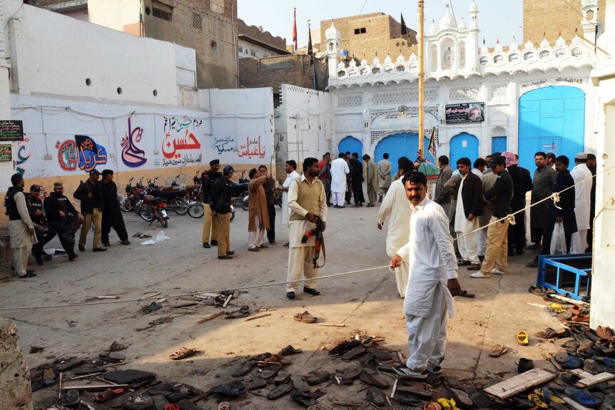 Security officials gather at the scene following a bomb attack at a Shiite Muslim mosque
